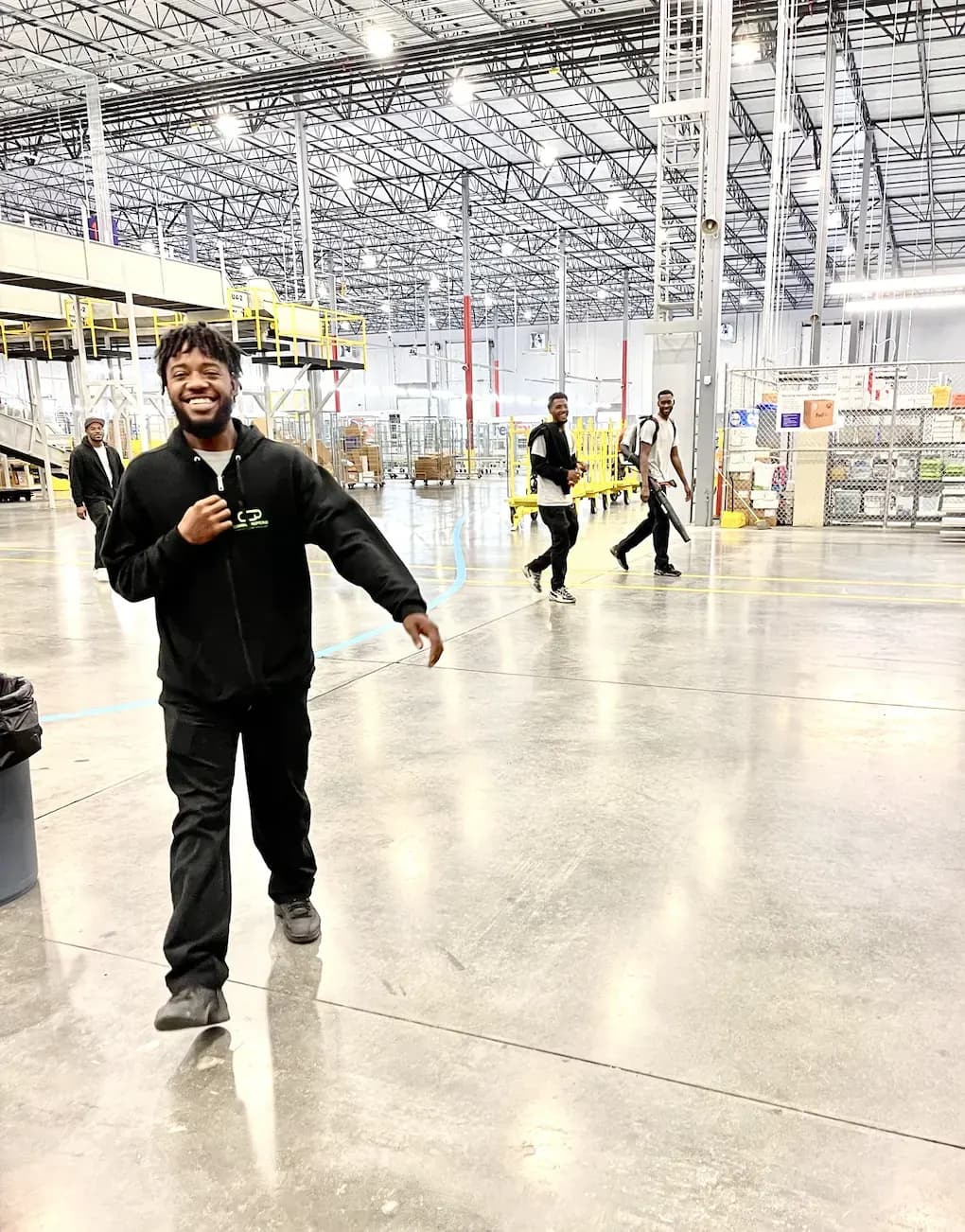 Cleaning Concepts Plus team member smiling on a clean warehouse floor