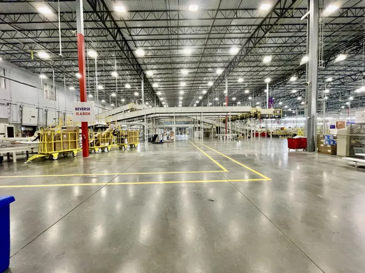 Wide distribution center aisle with clean polished concrete and yellow floor markings